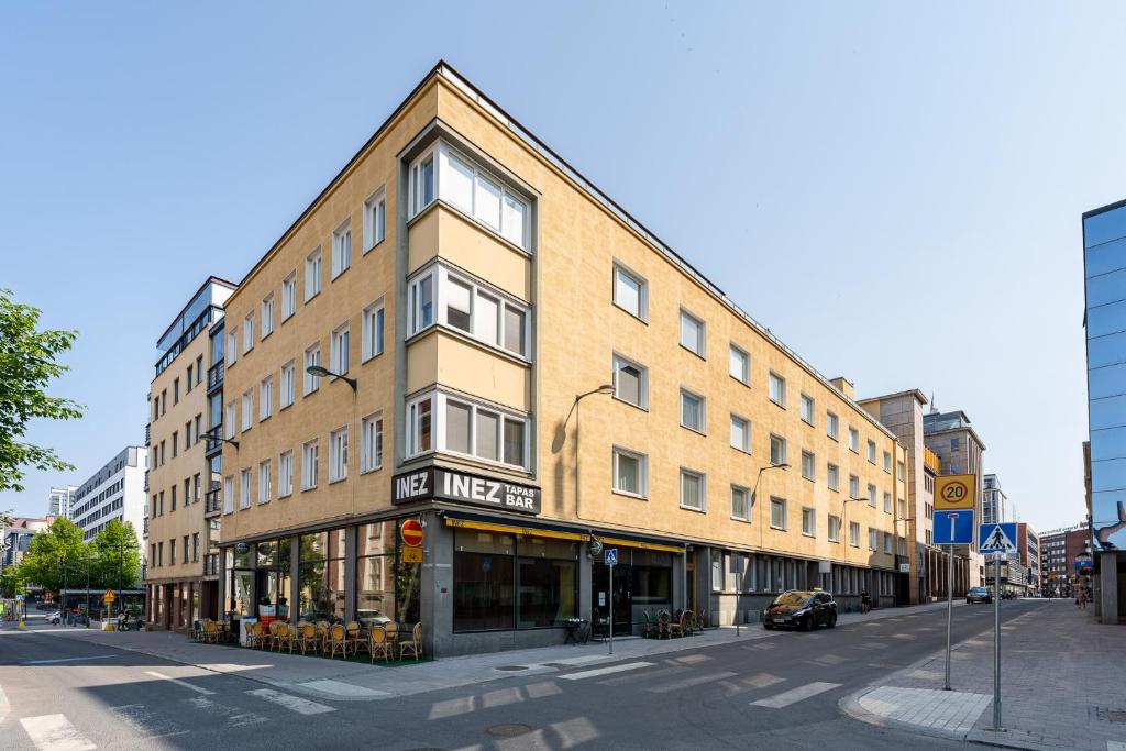 a large brick building on a street with a store at 2ndhomes Tampere "Koskipuisto" Apartment - Premium Downtown Apt with Own Sauna & a Tapas Restaurant Downstairs in Tampere