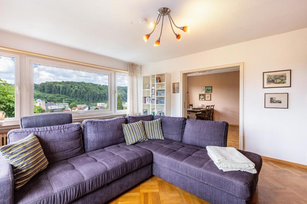 a living room with a purple couch and a large window at Ferienwohnung Lammerberg in Albstadt