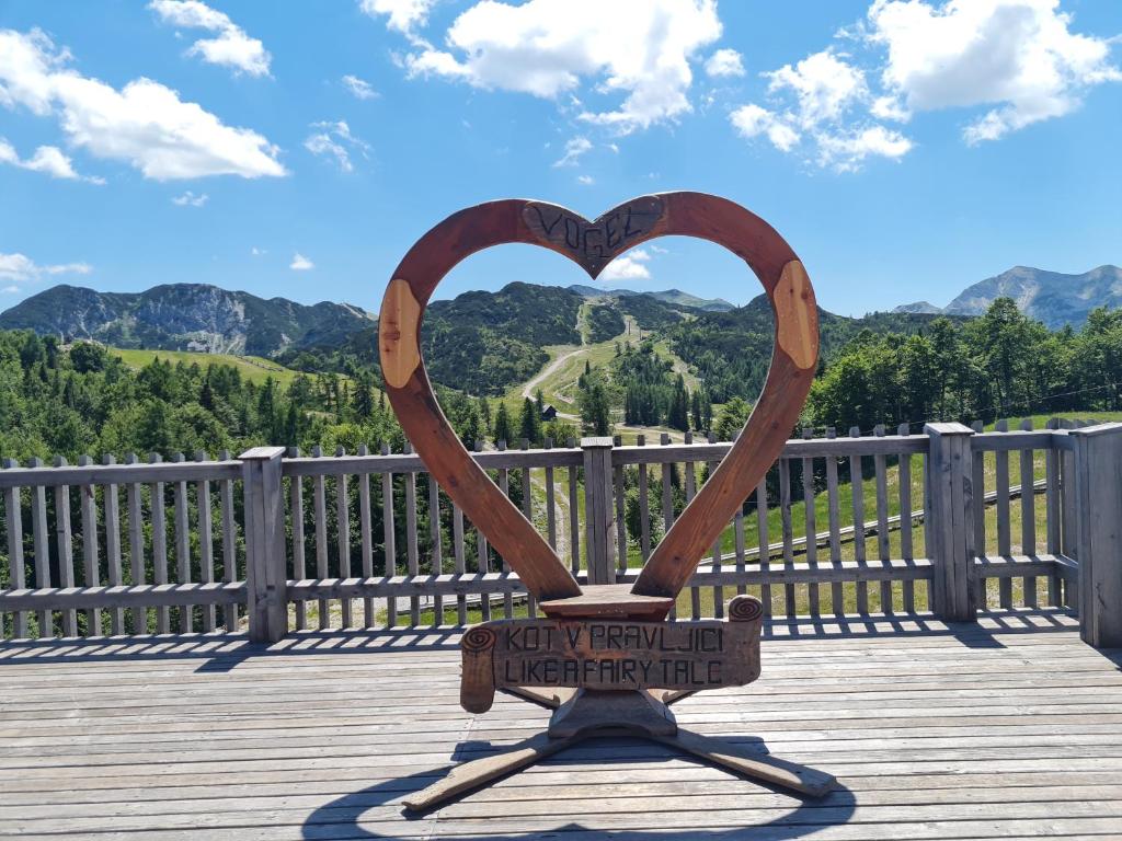 una scultura di cuore su una terrazza in legno con vista di Chalet Burja at Vogel mountain - cable car access or hiking - not reachable with car a Bohinj