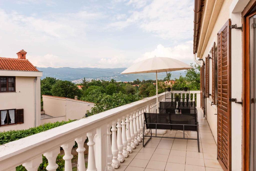 - un balcon avec une table et un parasol dans l'établissement Apartment in Silo with Two-Bedrooms 1, à Šilo