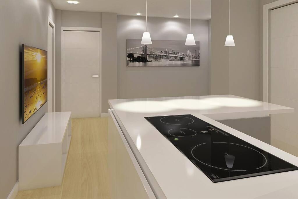 a white kitchen with a black stove top oven at Apartamento LA BEJARANA in Béjar