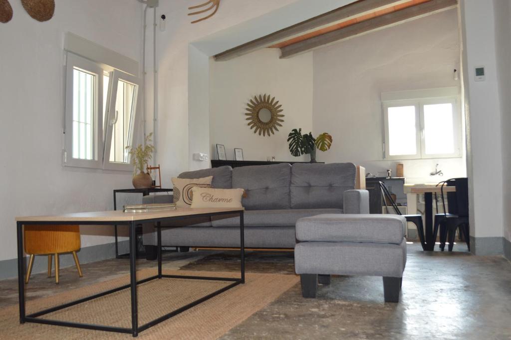 een woonkamer met een bank, een tafel en een stoel bij MASIA ESTORACH in L'Aldea