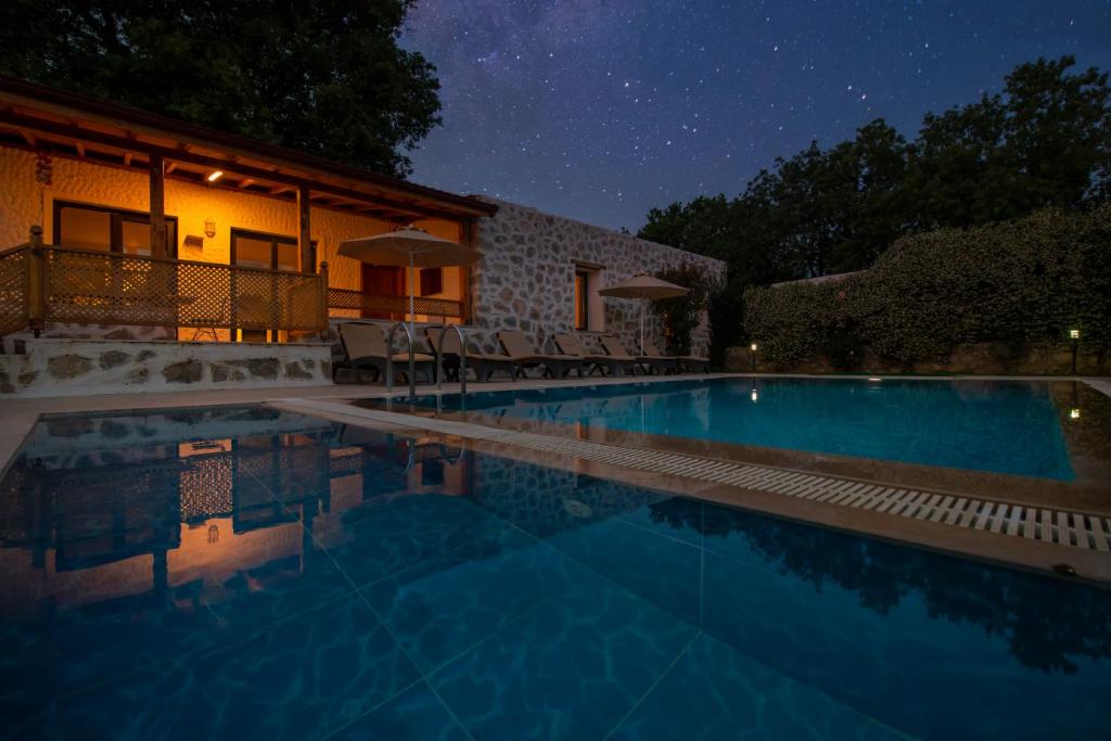 una piscina frente a una casa por la noche en Eroğlu Villas, en Fethiye