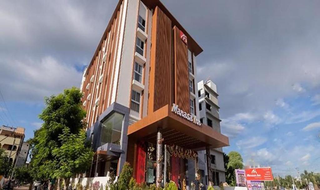 a tall building with a sign in front of it at FabHotel Prime Manasa Inn in Tirupati