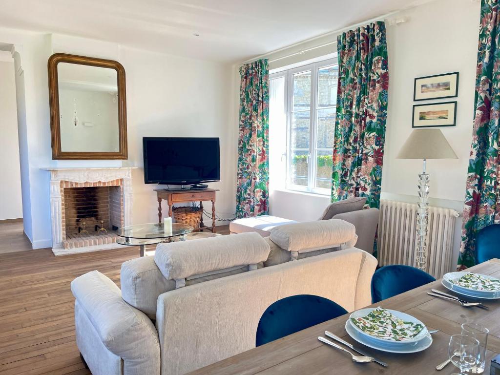 uma sala de estar com um sofá e uma lareira em L'Orangerie des Ursulines em Bayeux