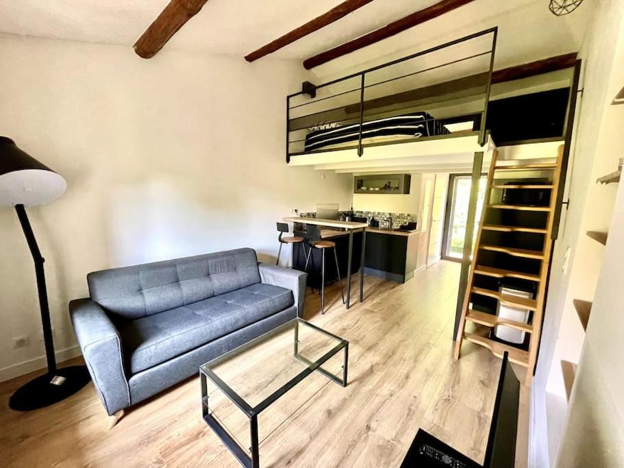 Il comprend un salon avec un canapé bleu et une cuisine. dans l'établissement Ravissant appartement à 5min du centre ville d'Aix, à Aix-en-Provence