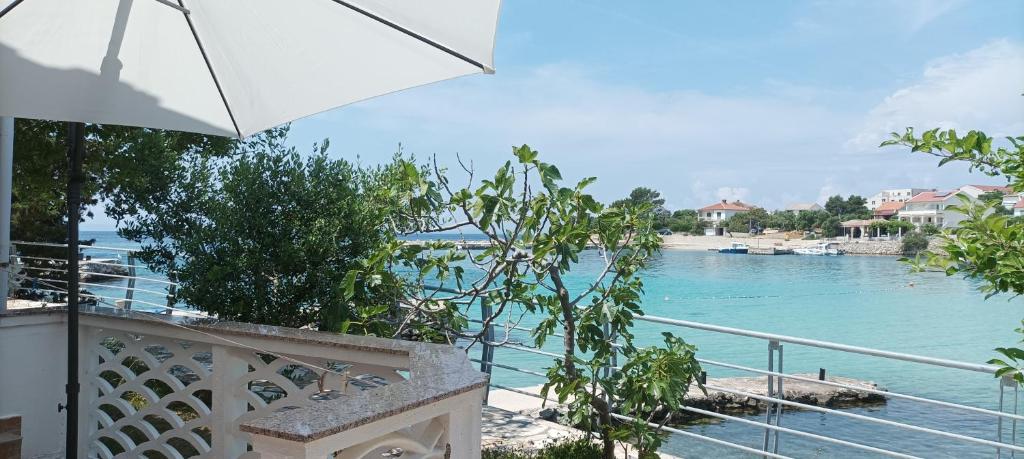 a view of the water from a balcony with an umbrella at Beachfront House Ugor in Lun