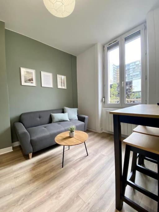 un salon avec un canapé et une table dans l'établissement L'idéal, à Saint-Étienne