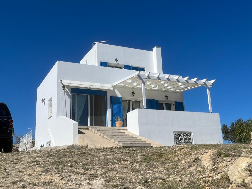 ein weißes Haus auf einem Hügel in der Unterkunft Amalia's Summer Home in Áyioi Asómatoi