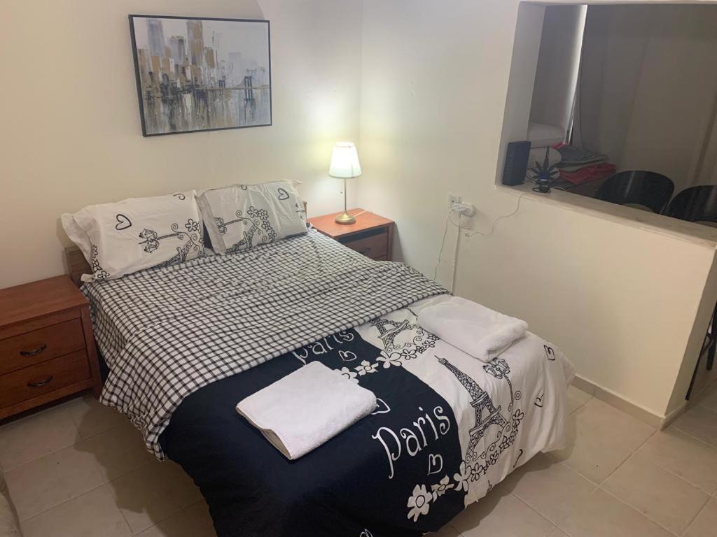 - une chambre avec un lit et une couverture noire et blanche dans l'établissement משמר הגבול 9 דירה 4, à Haïfa