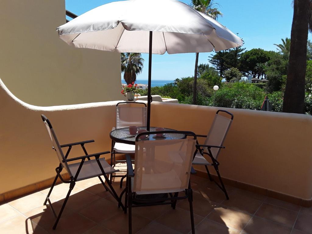 una mesa y sillas con una sombrilla en el balcón en Beach and Pools La Cala Mijas & Fuengirola by H&H, en Fuengirola
