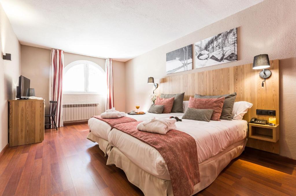 a bedroom with a large bed and a large window at Hotel Grand Pas in Pas de la Casa
