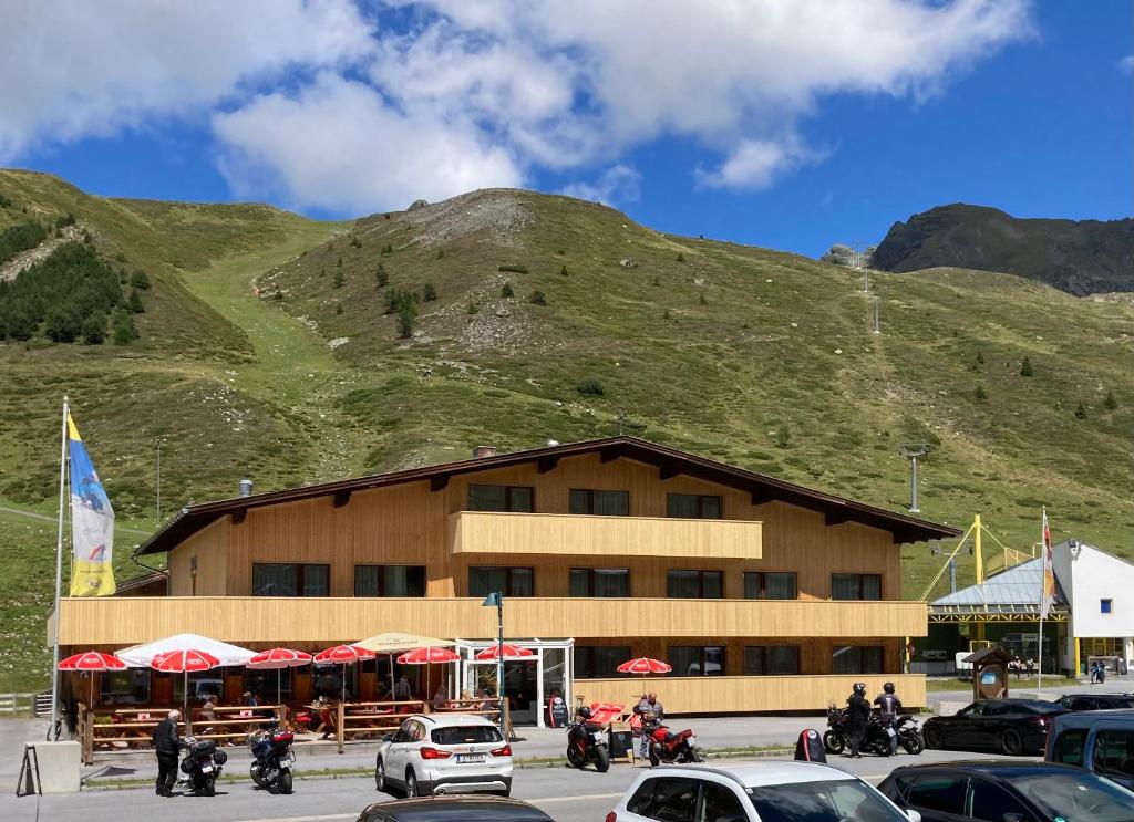 a building with motorcycles parked in front of a mountain at Gasthof Sonne & Schnee in Kühtai in Kühtai