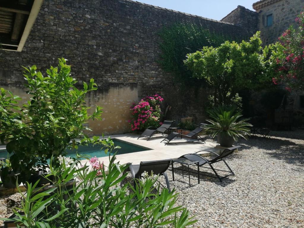 een patio met stoelen en bloemen op een binnenplaats bij Gîte d'Emeline in Bourdic