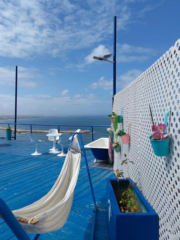 a hammock on a deck with the ocean in the background at Riad Ras Lafaa in Safi