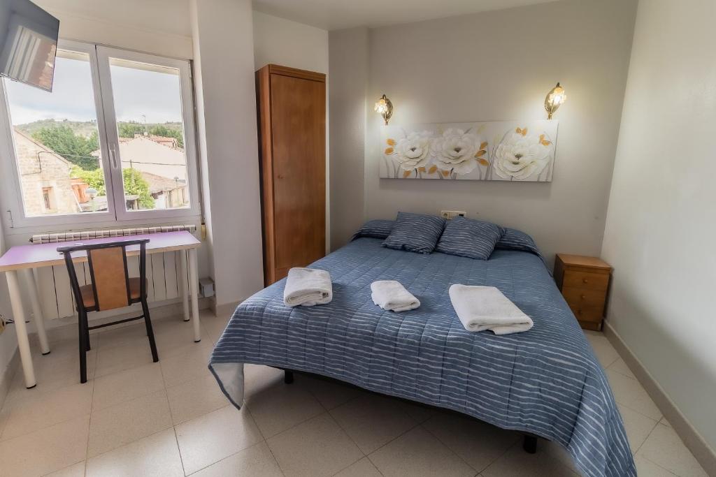 sypialnia z łóżkiem z dwoma ręcznikami w obiekcie Hostal - Restaurante La Buena Villa by Vivere Stays w mieście Villalonquéjar