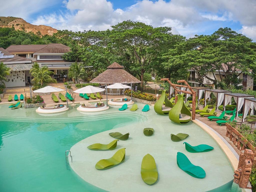 a pool at a resort with slides and chairs at Tag Resort in Coron