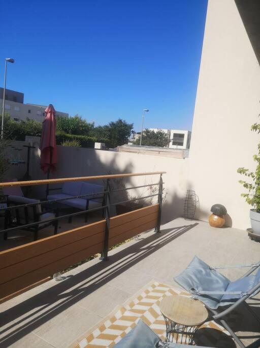 a patio with a table and chairs on a balcony at Villa contemporaine à 10mn des plages in Lattes