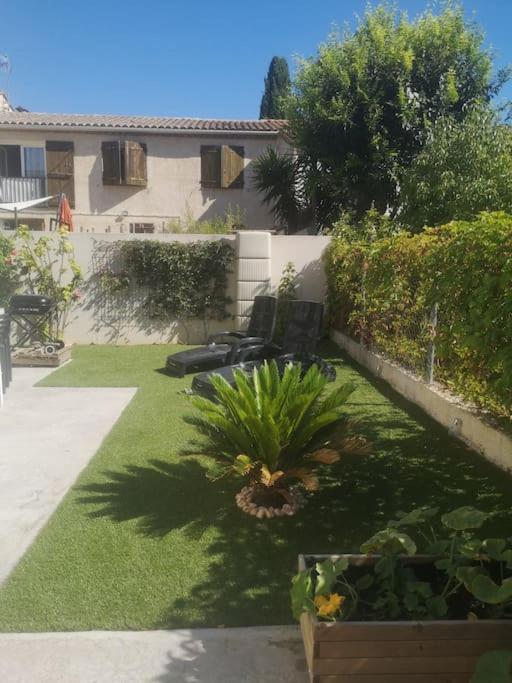 a yard with a garden with plants and a building at Villa contemporaine à 10mn des plages in Lattes