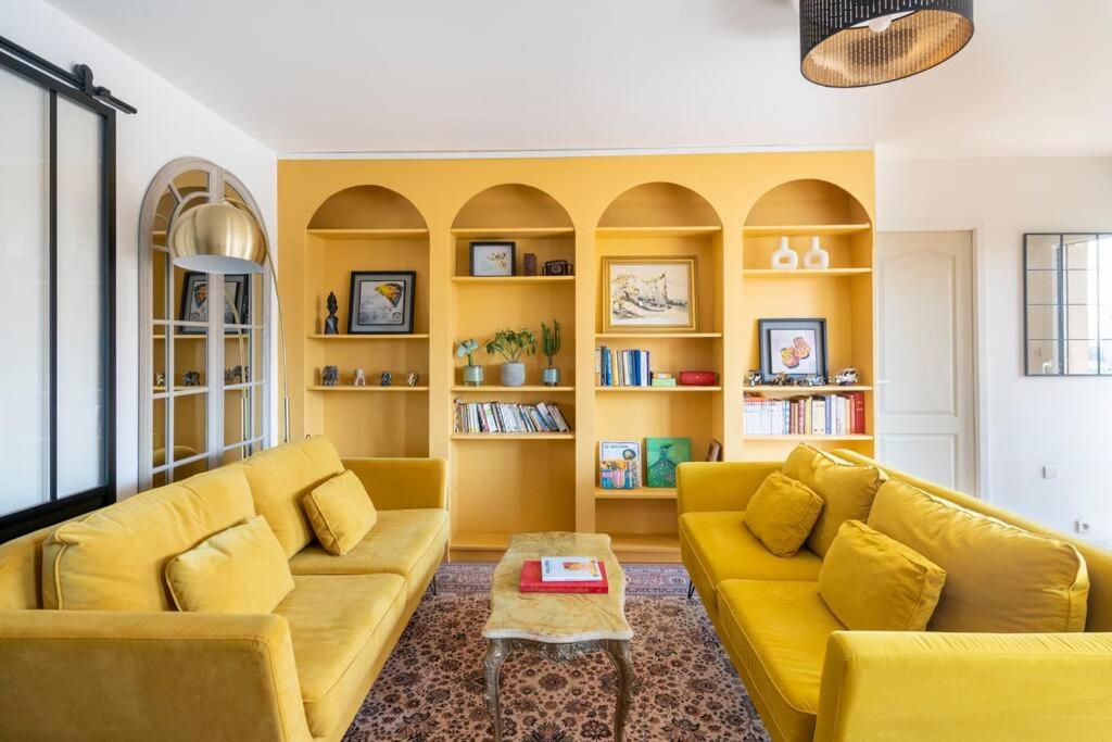a living room with yellow couches and a table at City Escape in Le Bourget