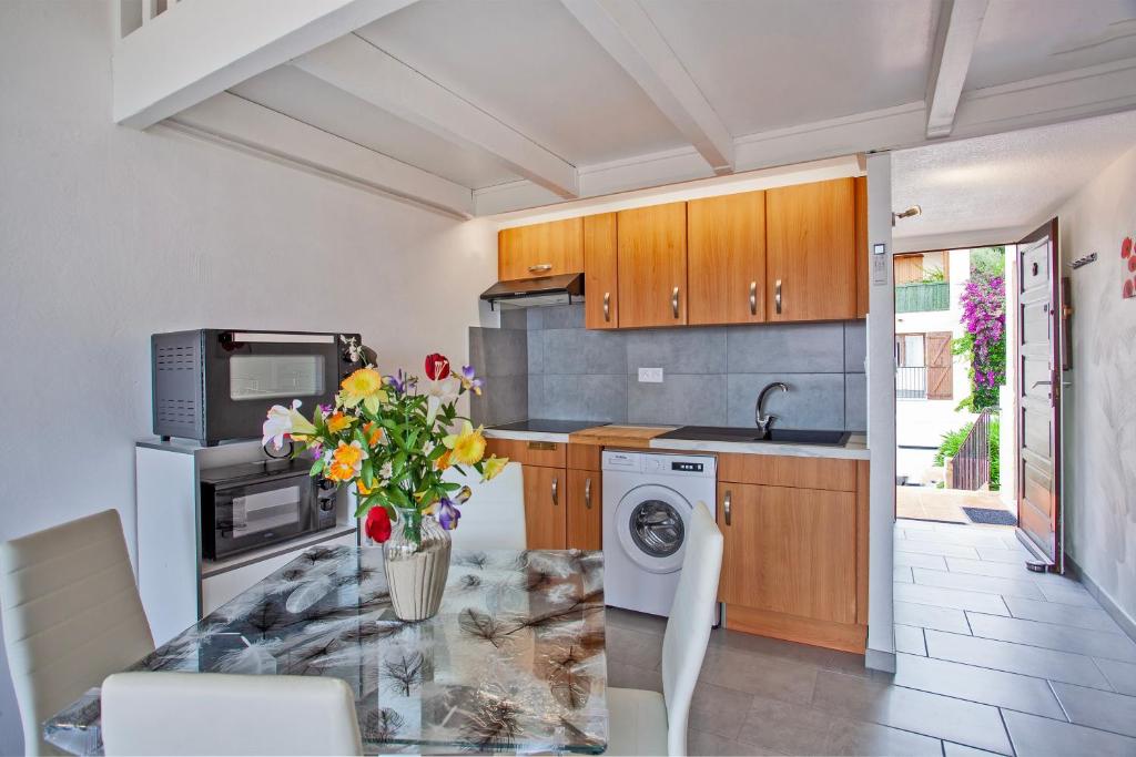 une cuisine avec une table avec un vase de fleurs dans l'établissement San Lucianu - Appt vue mer et montagne, à LʼÎle-Rousse