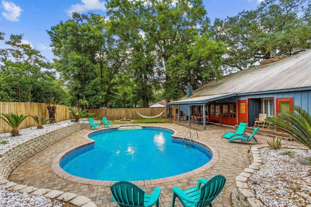a swimming pool with chairs and a house at 4527 Whisper Way in Pensacola