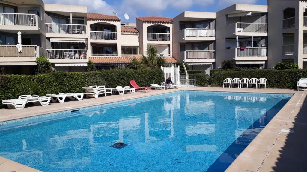 a swimming pool in front of some apartment buildings at Residence EDEN - 300m de la mer , parking privatif inclus in Juan-les-Pins