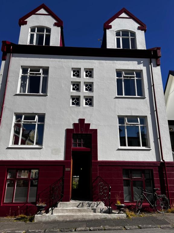 un bâtiment rouge et blanc avec une tour dans l'établissement Gerður Apartments, à Reykjavik