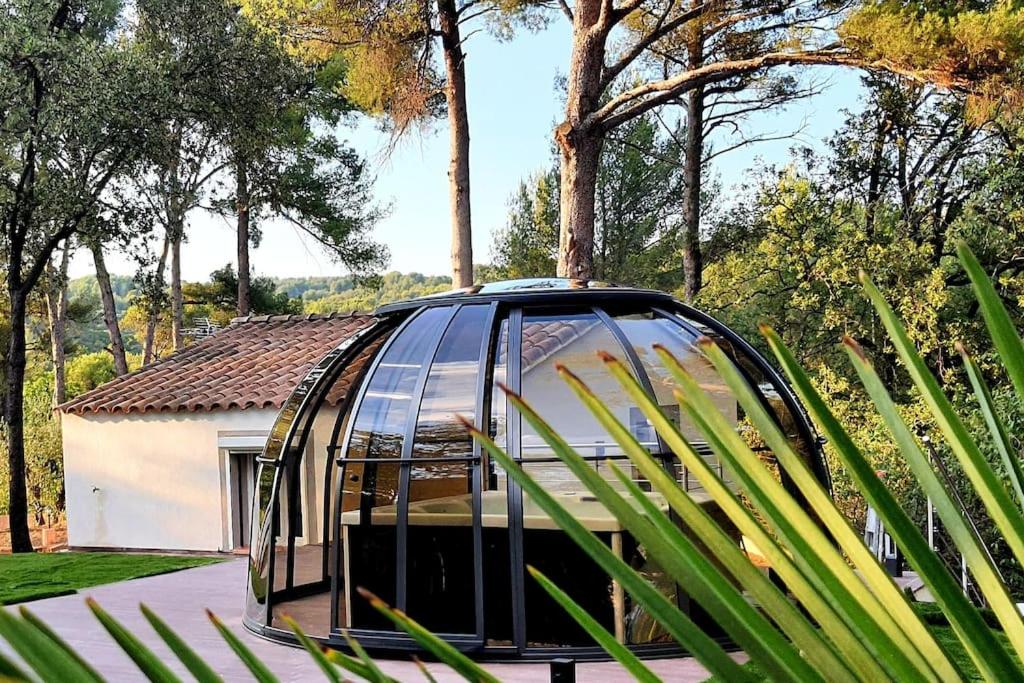 een glazen huis in een tuin met bomen bij Marseille - Love House Jacuzzi - La Bonne Etoile ! in Marseille