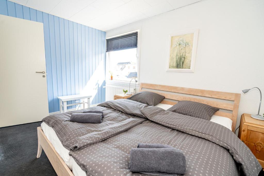 a bedroom with a large bed with two pillows at Parkvejens feriebolig in Bindslev