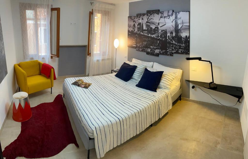 a bedroom with a large bed and a yellow chair at CasaBella Chioggia in Chioggia