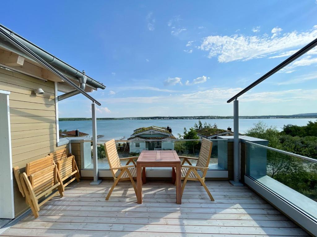 eine Terrasse mit einem Tisch und Stühlen auf dem Balkon in der Unterkunft HAUS IM SCHILF 2 - Ferienwohnungen am Hainer See bei Leipzig in Neukieritzsch