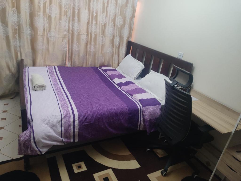 a bed in a room with a purple comforter at Classy Spacious Studio - Waiyaki Way 
