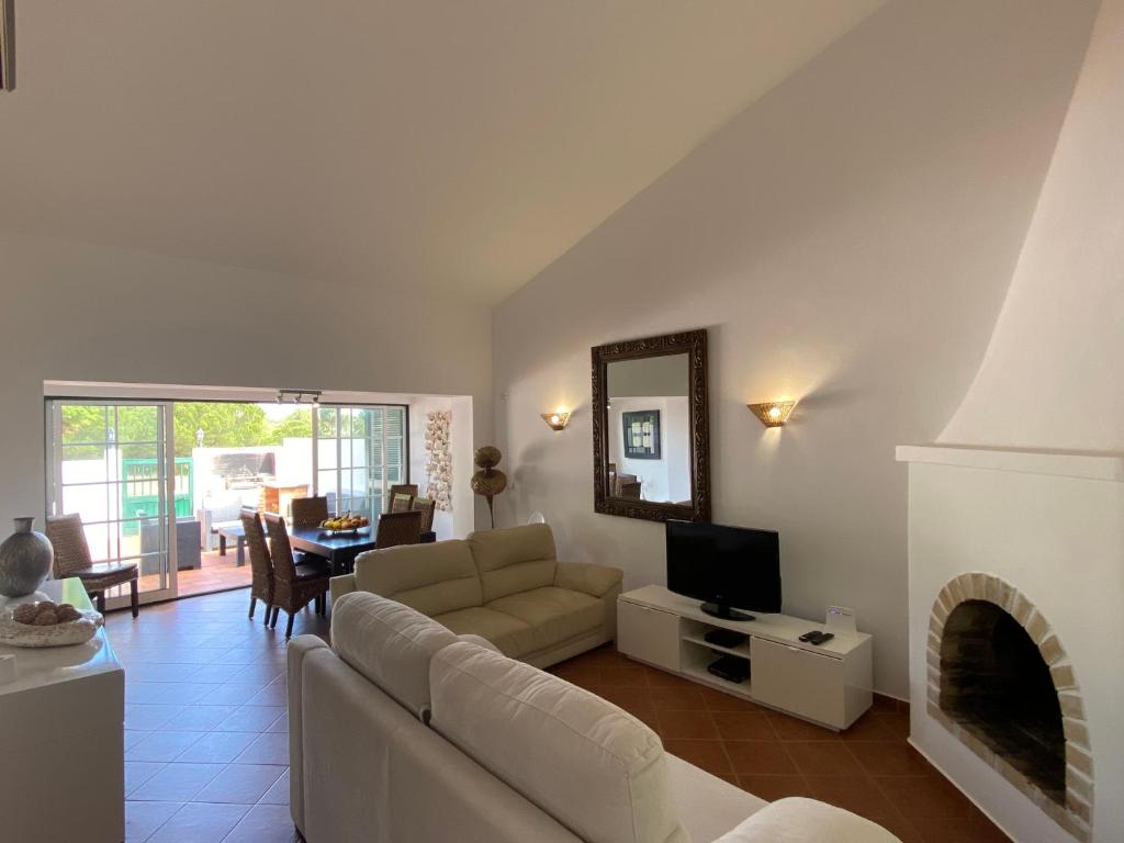 uma sala de estar com um sofá e uma televisão em Alfamar V3 Falésia Beach em Albufeira