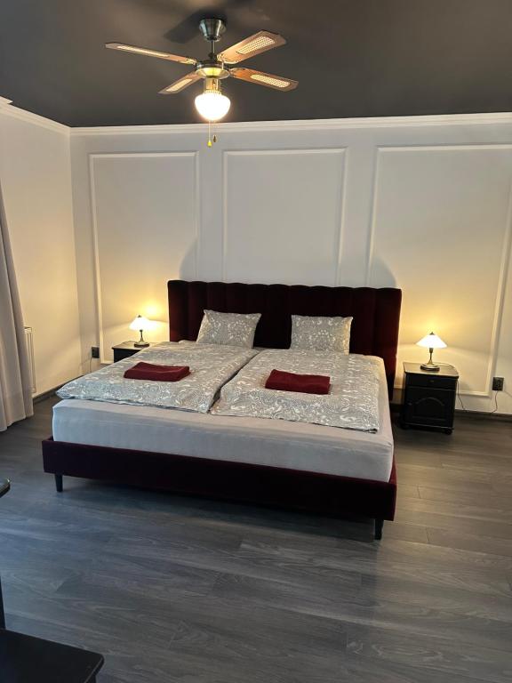 a bedroom with a large bed with a ceiling fan at Noclegi Apartamenty Amla 
