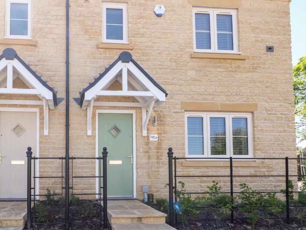 a brick house with a green front door at Beaus House in Cheltenham