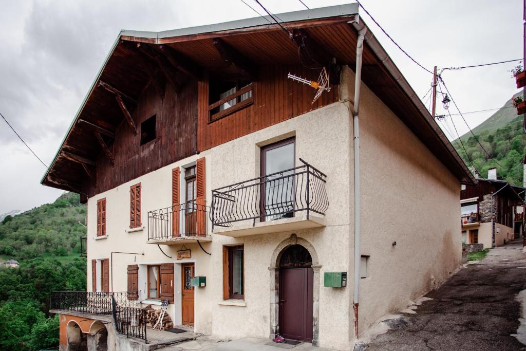 an old house with a porch and a balcony at Maison 3 Vallées Val Thorens in Novallay