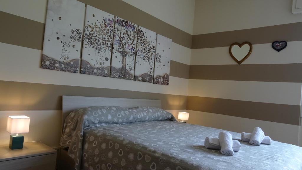 una camera da letto con un letto e un dipinto a cuore sul muro di Casa Vacanze da Emanuela a Darfo
