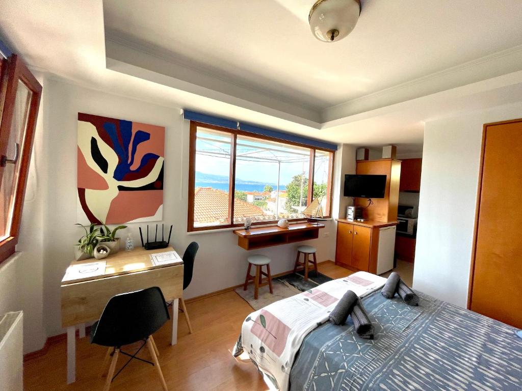 Schlafzimmer mit einem Bett, einem Schreibtisch und einem Fenster in der Unterkunft Nafpaktos Castle Studio in Nafpaktos