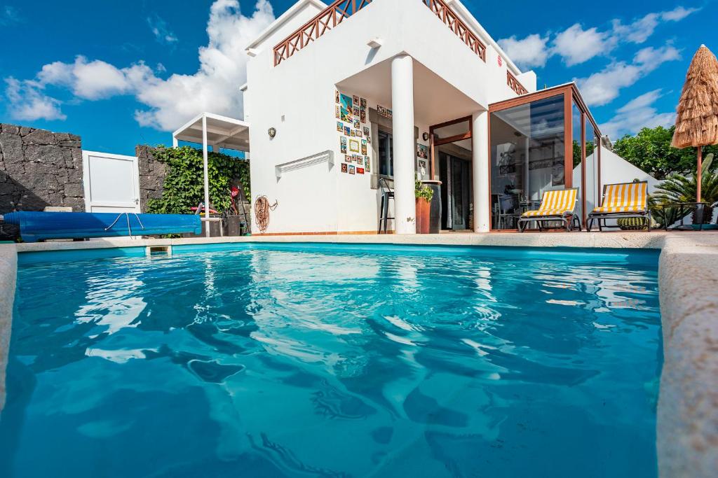 a villa with a swimming pool in front of a building at Casa ERNESTO in Playa Blanca