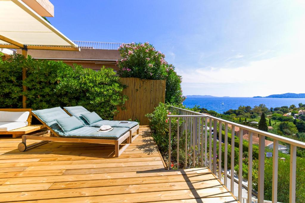 une terrasse en bois avec un banc sur un balcon dans l'établissement SELECT'soHOME - Splendide Mazet avec vue mer à La Fossette - SOLE&MARE, au Lavandou