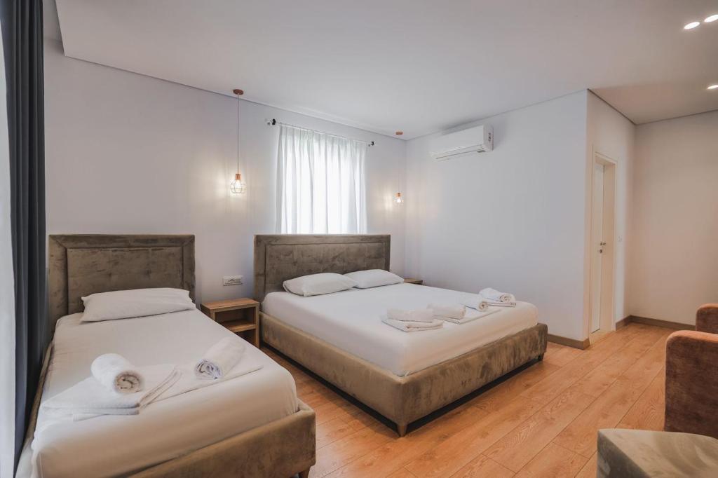 a room with two beds and a couch at Otto Hotel in Ksamil