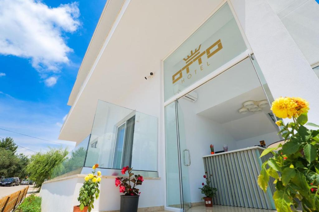 a white building with a sign on it at Otto Hotel in Ksamil