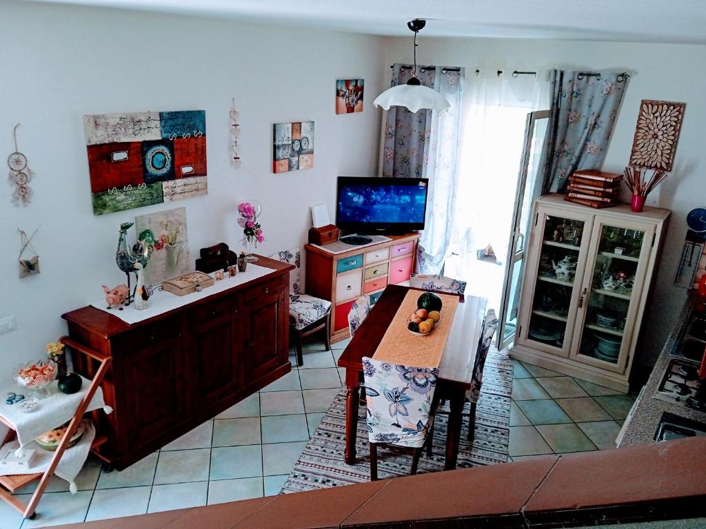 uma sala de estar com uma mesa e uma televisão em Vivere in famiglia em Orosei