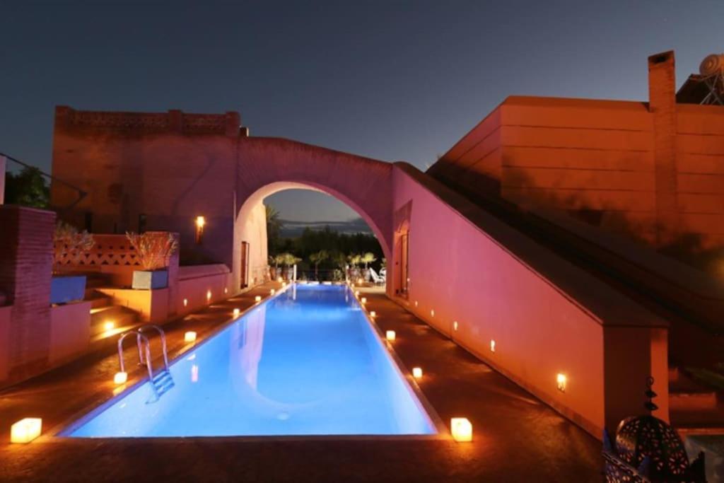 a large swimming pool in a building at night at Villa Jolyamelkis - golf Marrakech in Marrakesh
