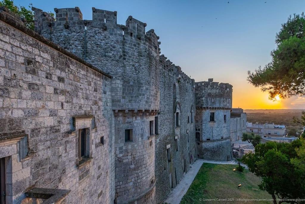 een groot kasteel met een zonsondergang op de achtergrond bij La casa sotto il castello! in Carovigno