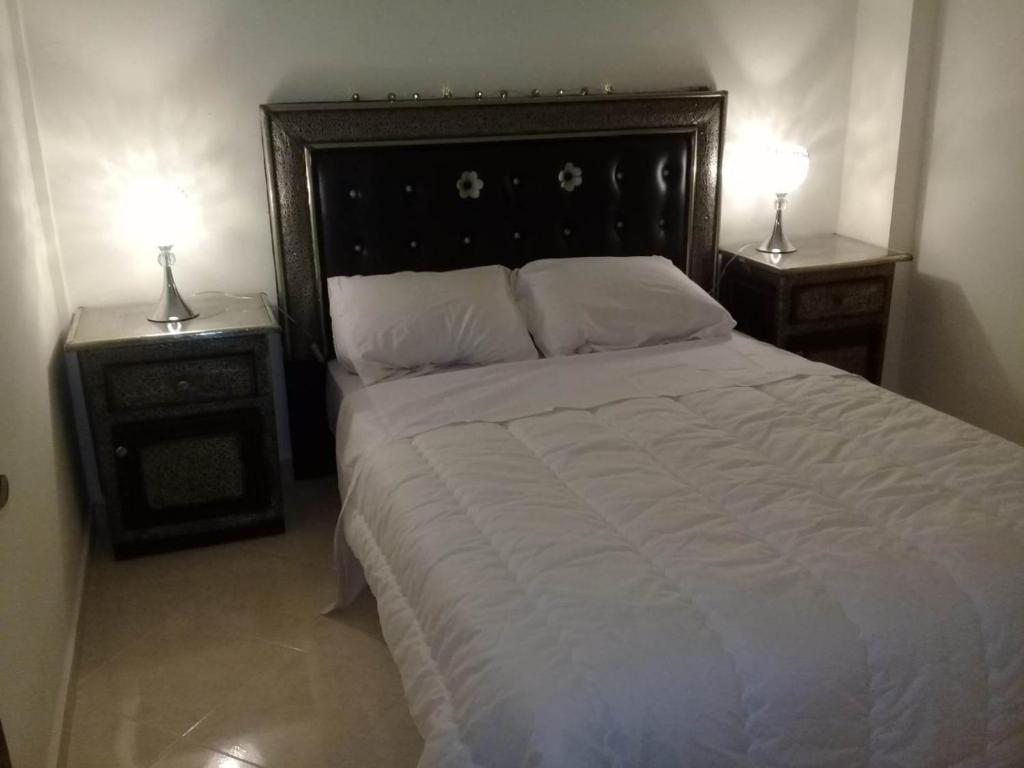 sypialnia z dużym łóżkiem i 2 szafkami nocnymi w obiekcie appartement cosy à Marrakech w Marakeszu