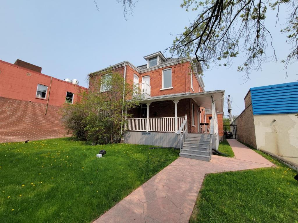 a brick house with a porch and a yard at Stone House Kenora in Kenora