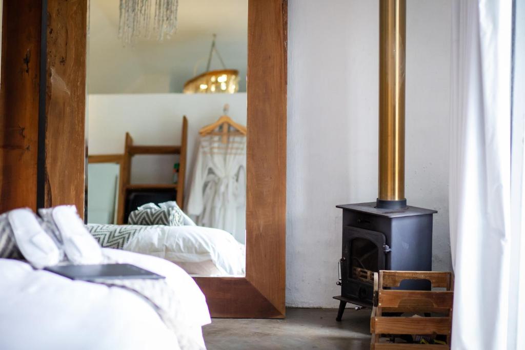 a bedroom with a wood stove in front of a mirror at Qambathi Mountain Lodge - Adults only in Rev Estates