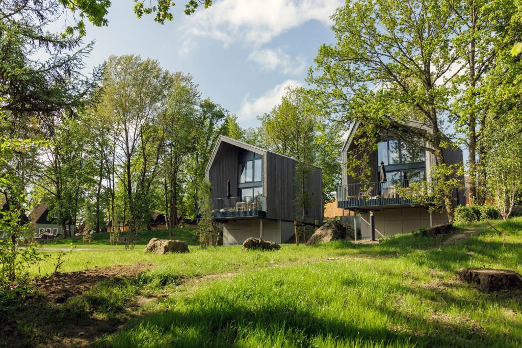 uma casa numa colina com um jardim verde em Center Parcs Eifel Mosel Nürburgring em Gunderath